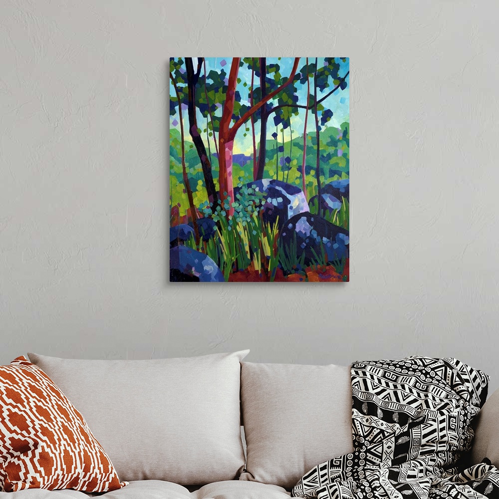 A bohemian room featuring Painting of tree with red bark in the forest beside large blue and purple rocks.