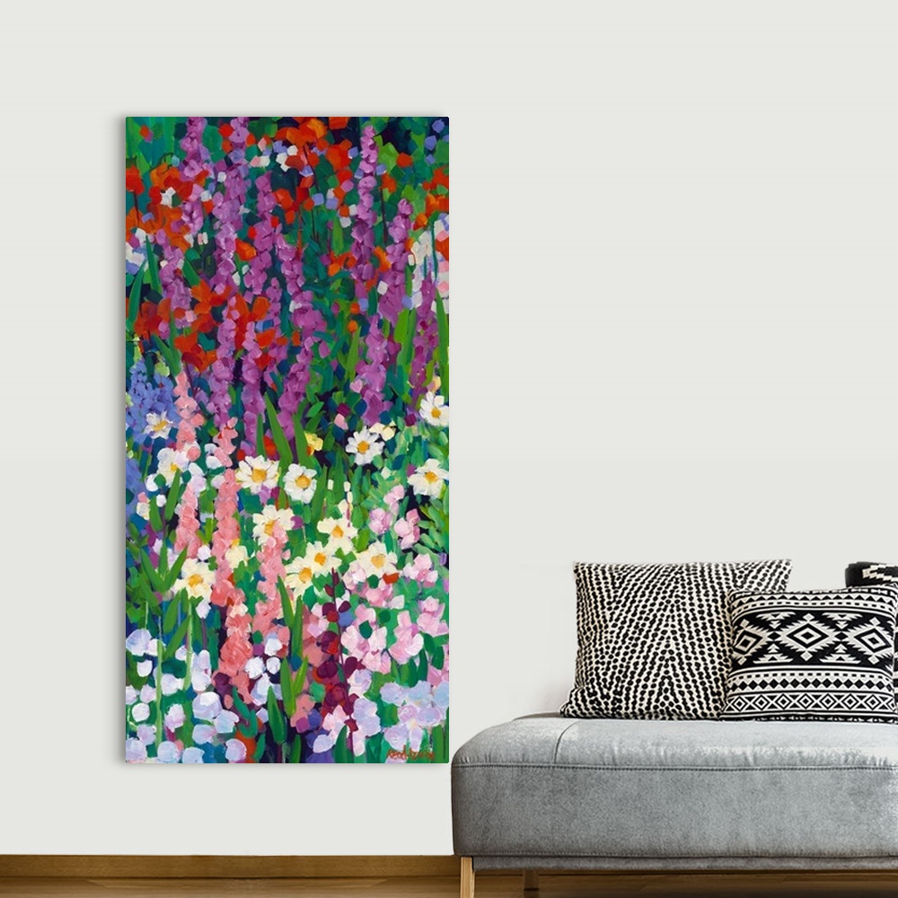 A bohemian room featuring Tall narrow painting of flowers in a garden with daisies and red and purple spired blooms.