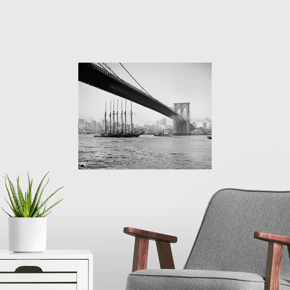 A modern room featuring Horizontal, vintage photograph of an old ship passing beneath the Brooklyn Bridge, along the East...