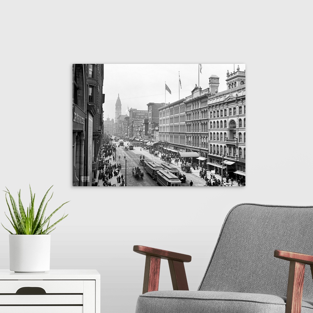 A modern room featuring Antiqued canvas photo print of old buildings with street cars and horses traveling through the mi...