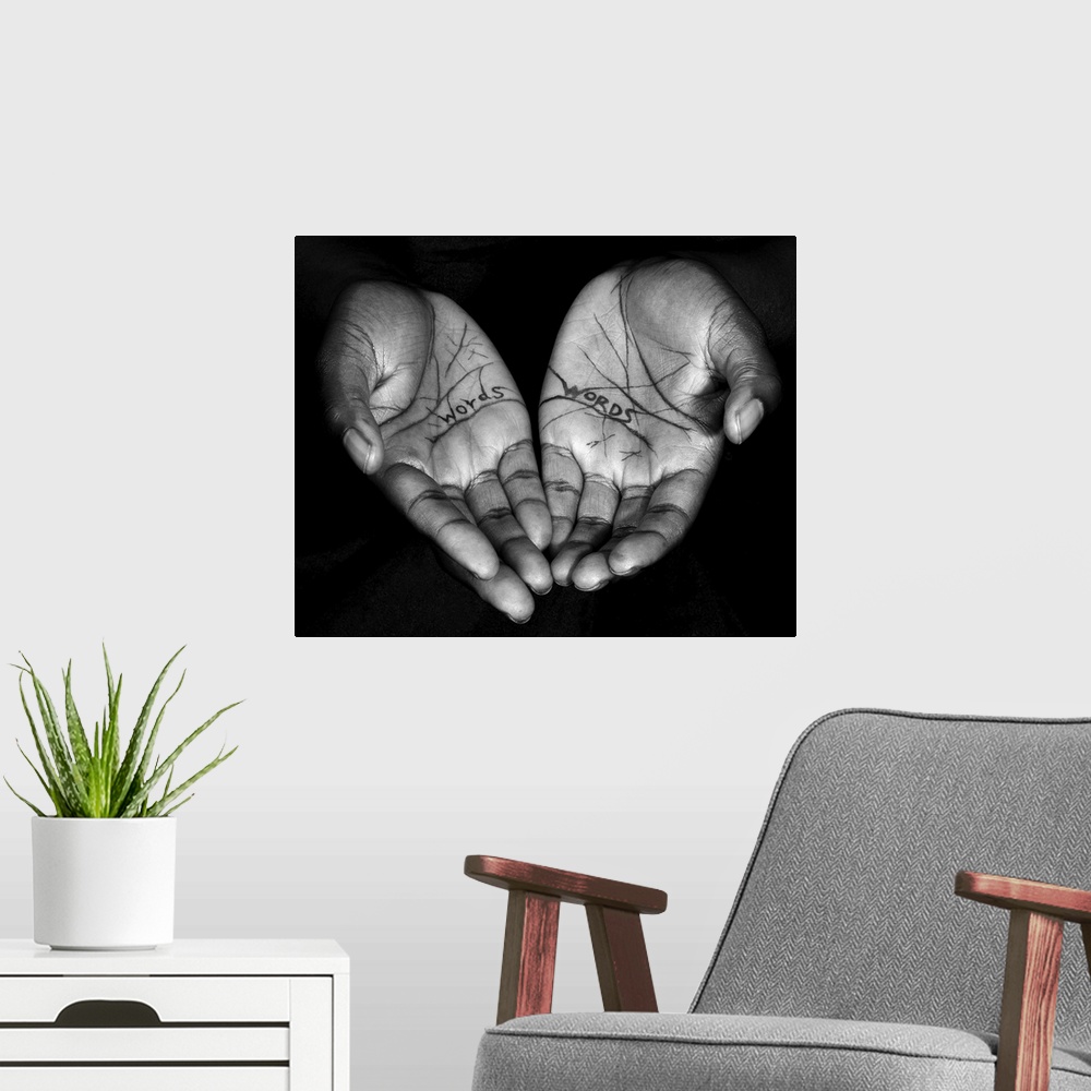 A modern room featuring A high impact contemporary black and white photograph of a pair of hands feadruing the words 'wor...