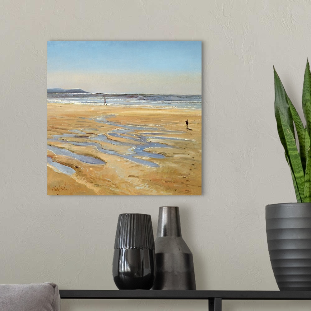 A modern room featuring Contemporary artwork of a person walking along the water on the beach as their dog runs toward th...
