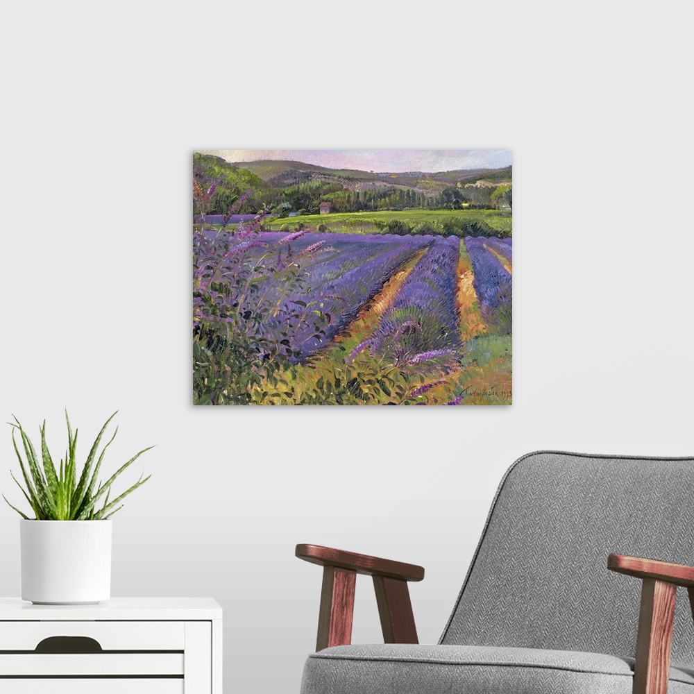 A modern room featuring Contemporary artwork of a lavender field that shows the flower close up with trees and hills seen...