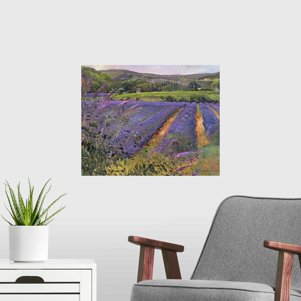 A modern room featuring Contemporary artwork of a lavender field that shows the flower close up with trees and hills seen...