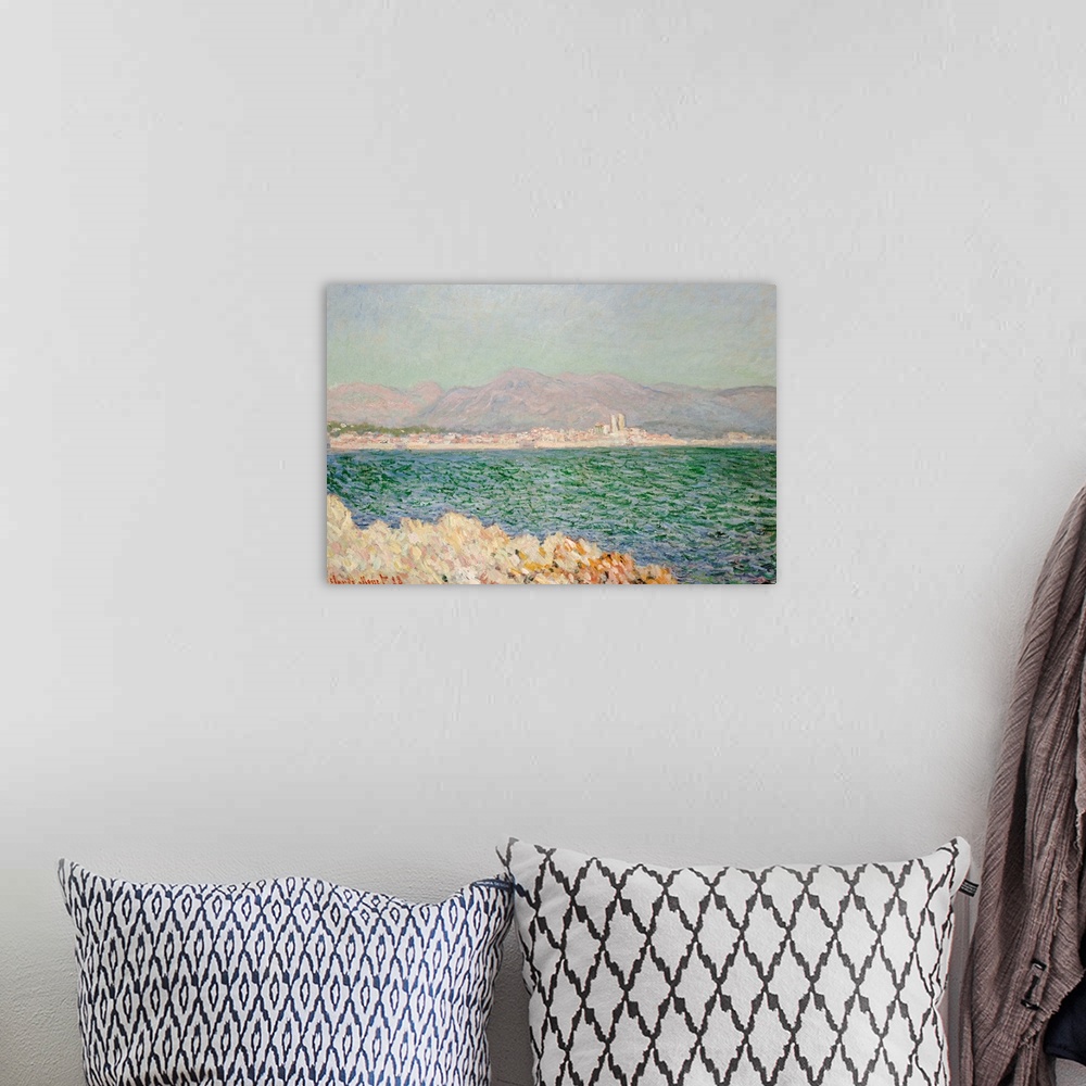A bohemian room featuring A piece of classic artwork with water in the foreground and buildings lining the beach behind it....