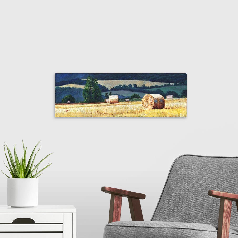 A modern room featuring Contemporary painting of a countryside scene with hay bails in a farmed field.