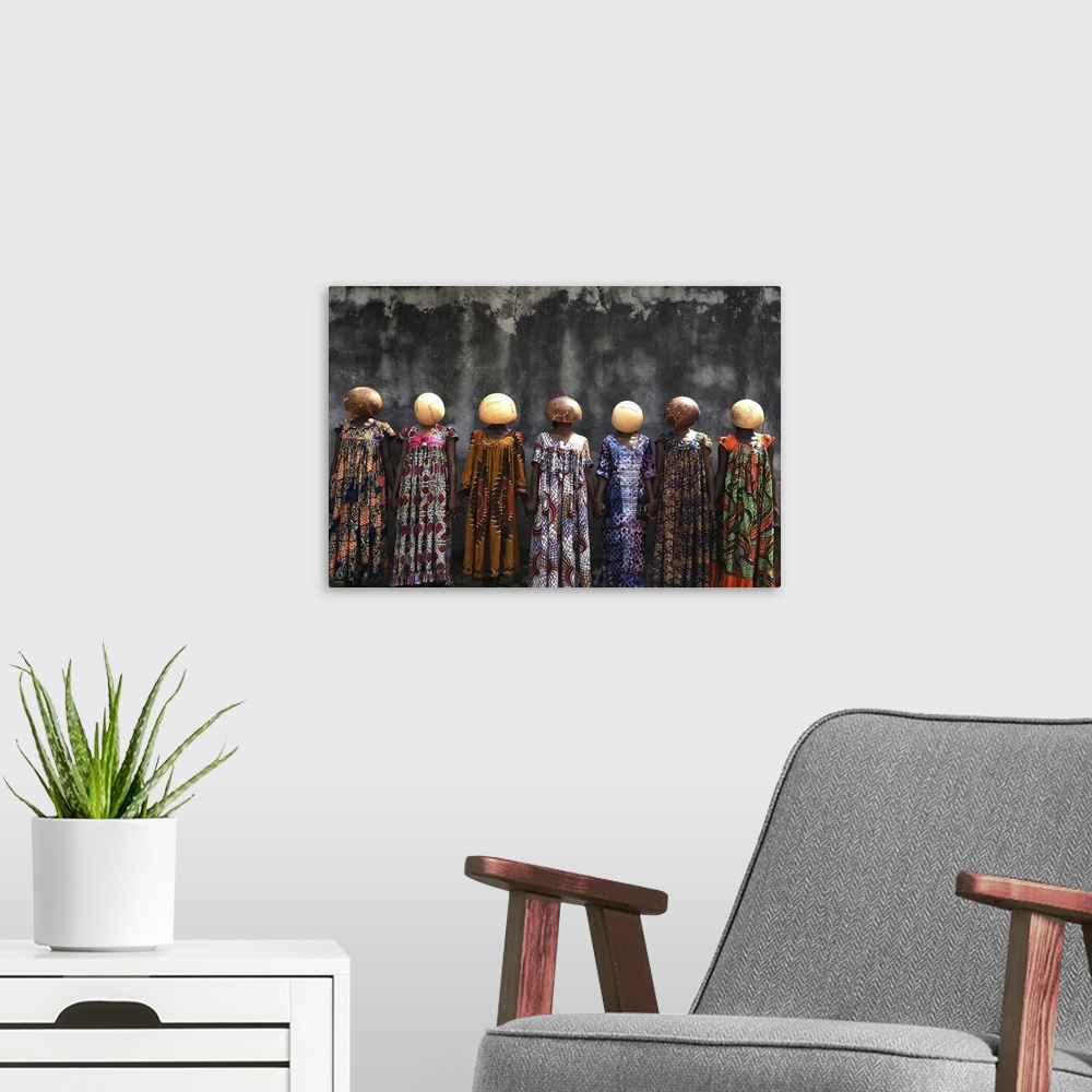 A modern room featuring A high-impact fine art photograph of a group of women wearing stitched calabash gourds on their h...