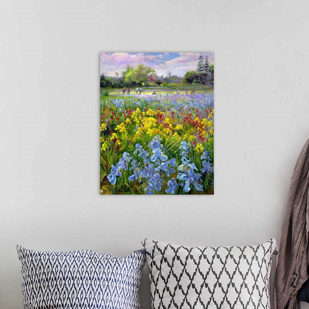 A bohemian room featuring Vertical, oversized floral painting of a field of multicolored irises, a large group of people in...
