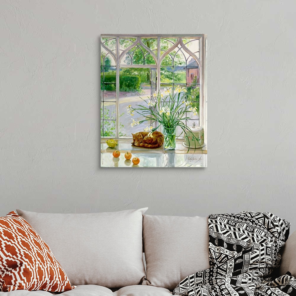 A bohemian room featuring Contemporary artwork of a large vase of flowers that stands in front of a big window with a cat c...