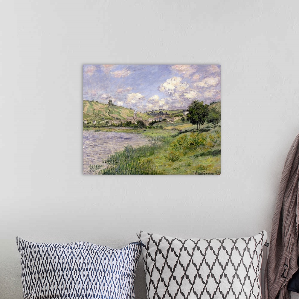 A bohemian room featuring Oil painting of countryside with rolling hills and lake under a cloudy sky.