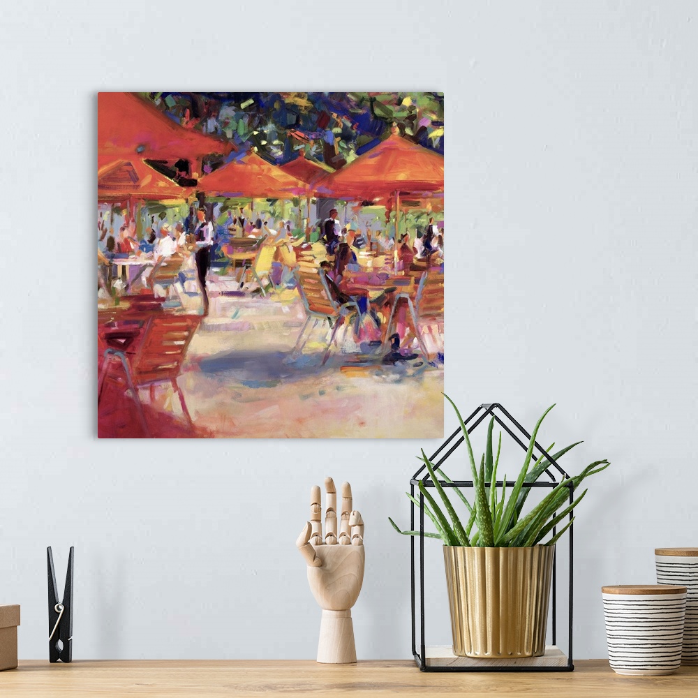 A bohemian room featuring Giant contemporary art shows a large number of people sitting at tables covered with umbrellas wh...