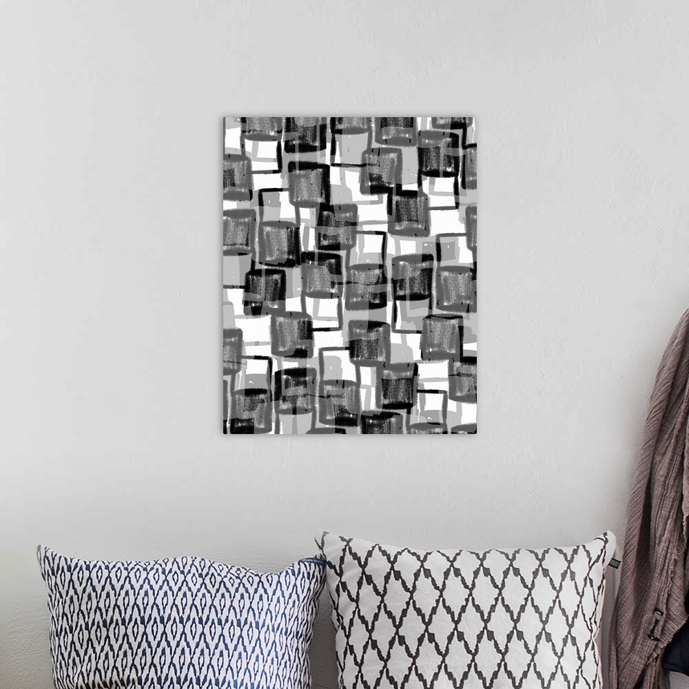 A bohemian room featuring An abstract piece of artwork that consists of black and grey squares in an erratic pattern.