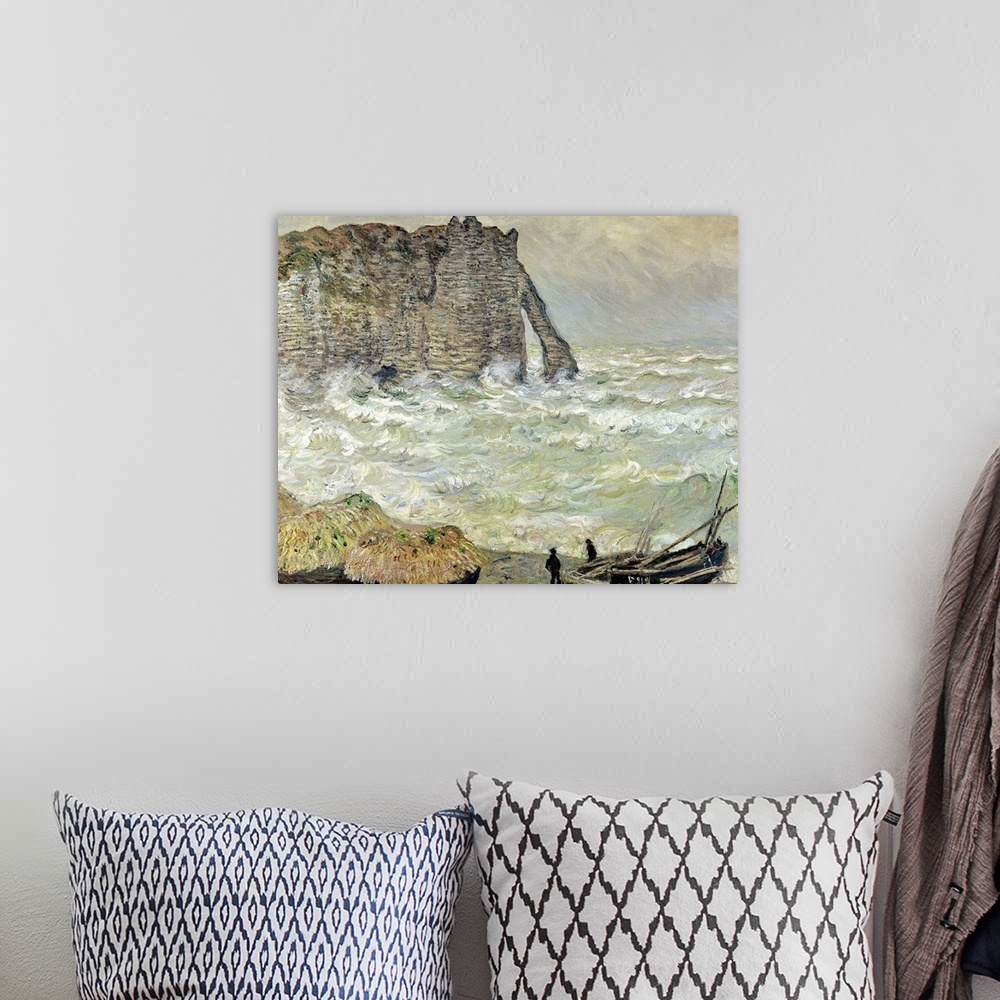 A bohemian room featuring A painting by Claude Monet of two men standing by beached boats as rough waves pound the beach an...