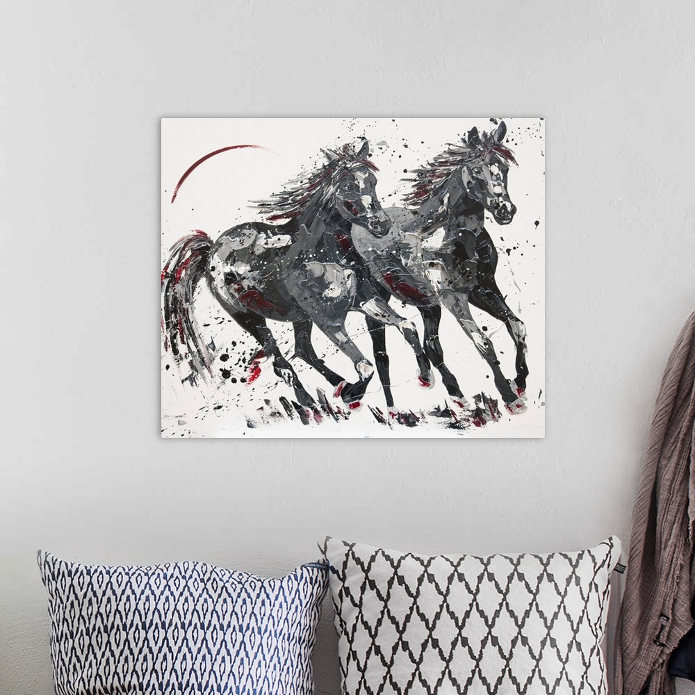 A bohemian room featuring Contemporary painting of two galloping horses in shades of black with red.