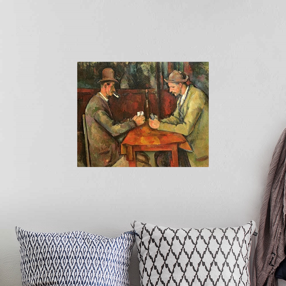 A bohemian room featuring Two men dressed in casual working class clothing play cards a small table with a bottle of wine i...