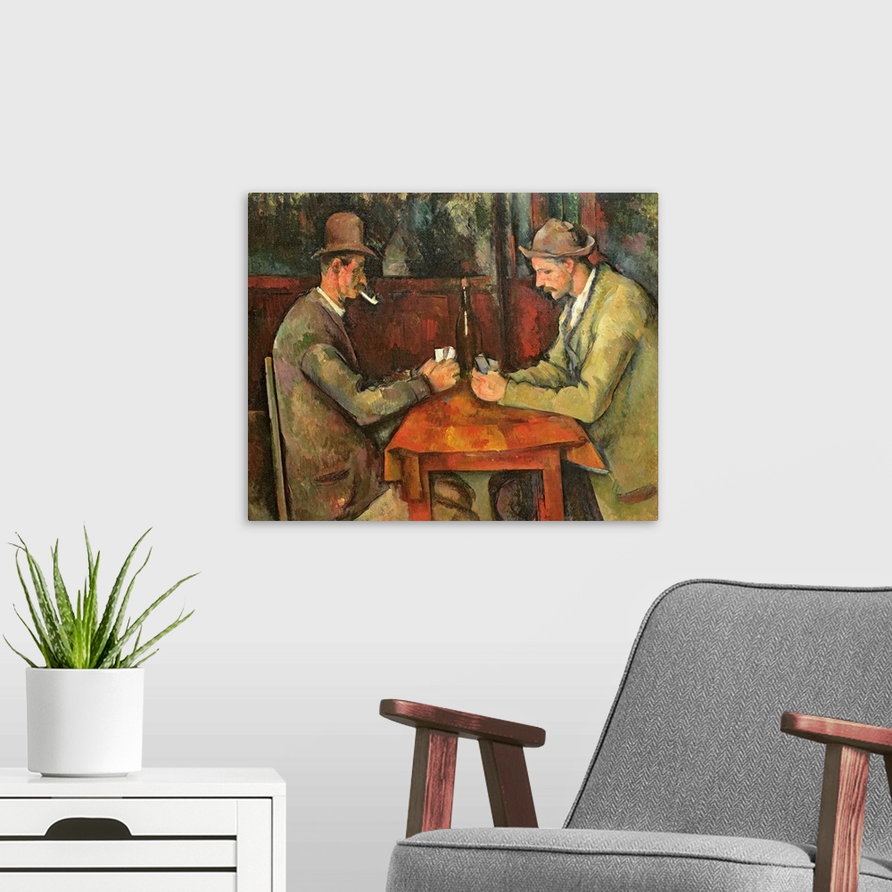 A modern room featuring Two men dressed in casual working class clothing play cards a small table with a bottle of wine i...