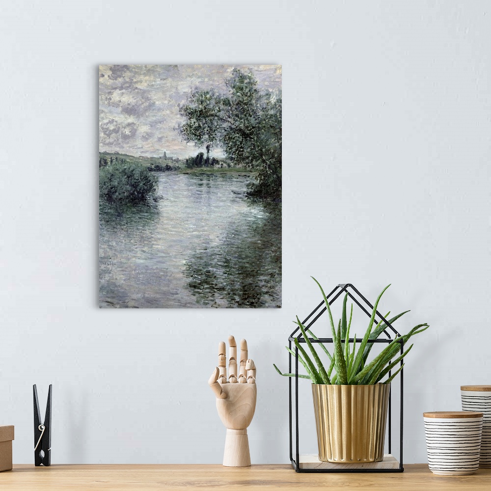 A bohemian room featuring A classic art piece of a body of water that has trees hanging over it and reflecting in it with l...