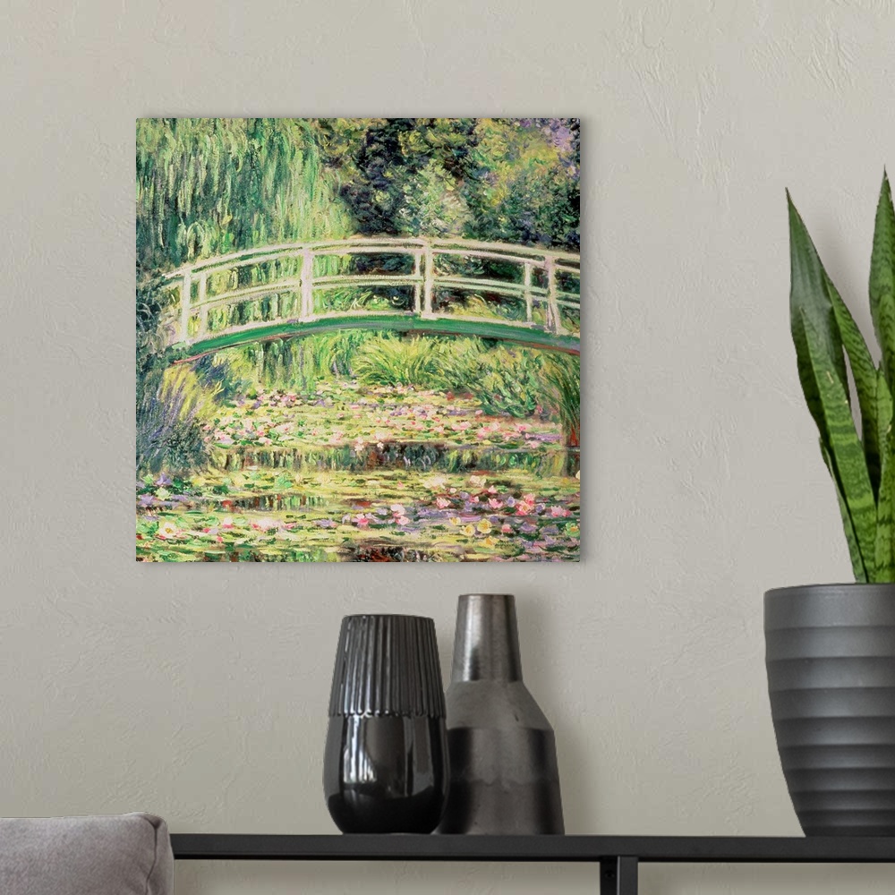 A modern room featuring This classic artwork is a painting of a small walking bridge over water that is covered with lily...