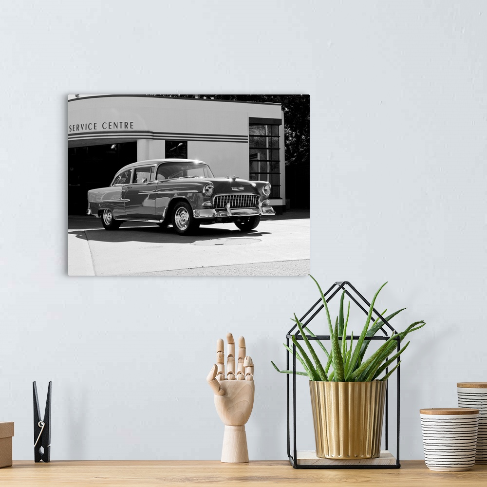 A bohemian room featuring Black and white photograph of a 1955 Chev Belair 7 in front of a service center.