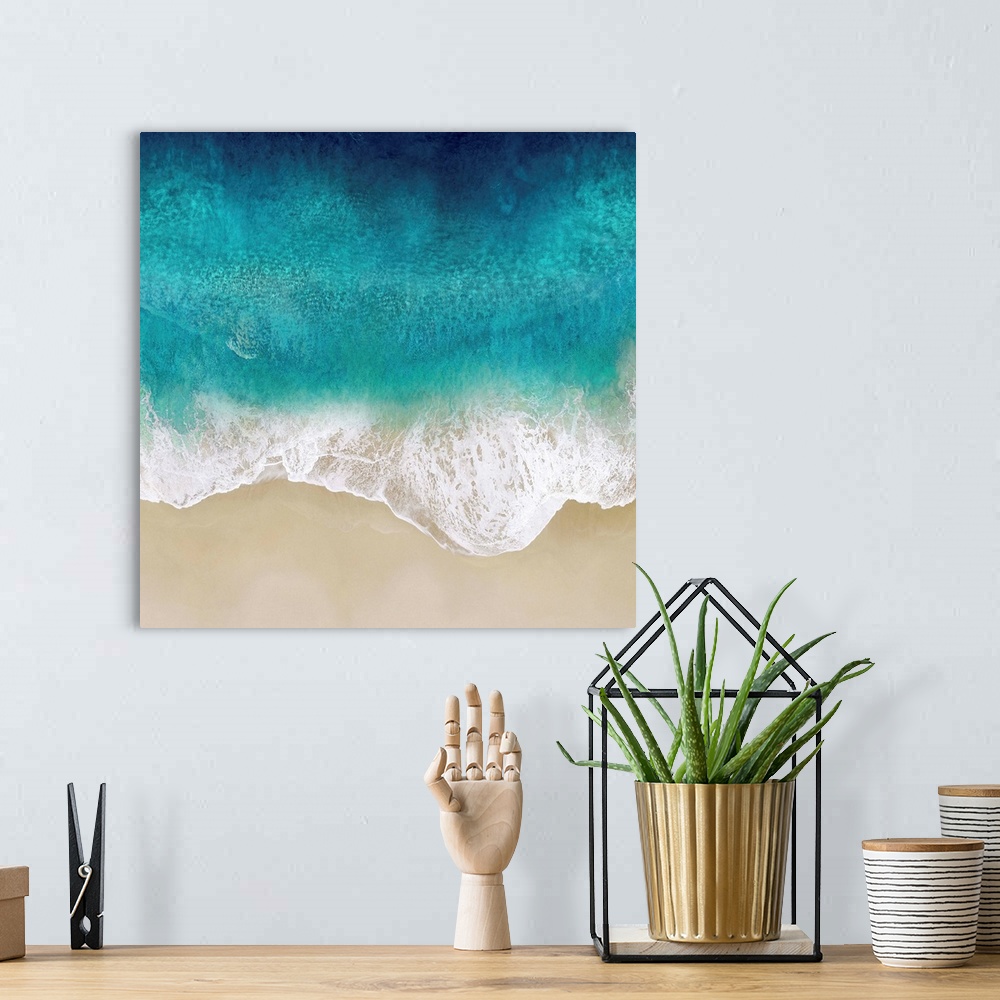A bohemian room featuring One artwork in a series of aerial shots of a beach as vibrant blue waves break upon the shore.