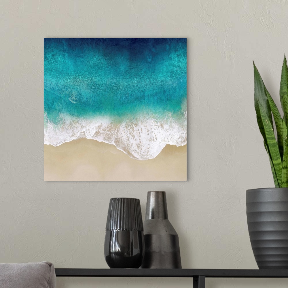 A modern room featuring One artwork in a series of aerial shots of a beach as vibrant blue waves break upon the shore.