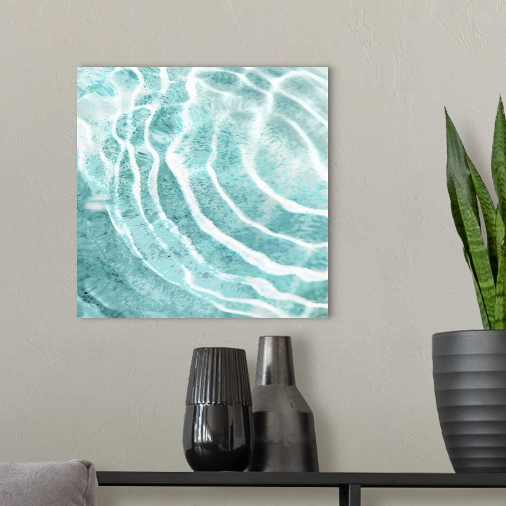 A modern room featuring Square photograph of ripples in clear water.