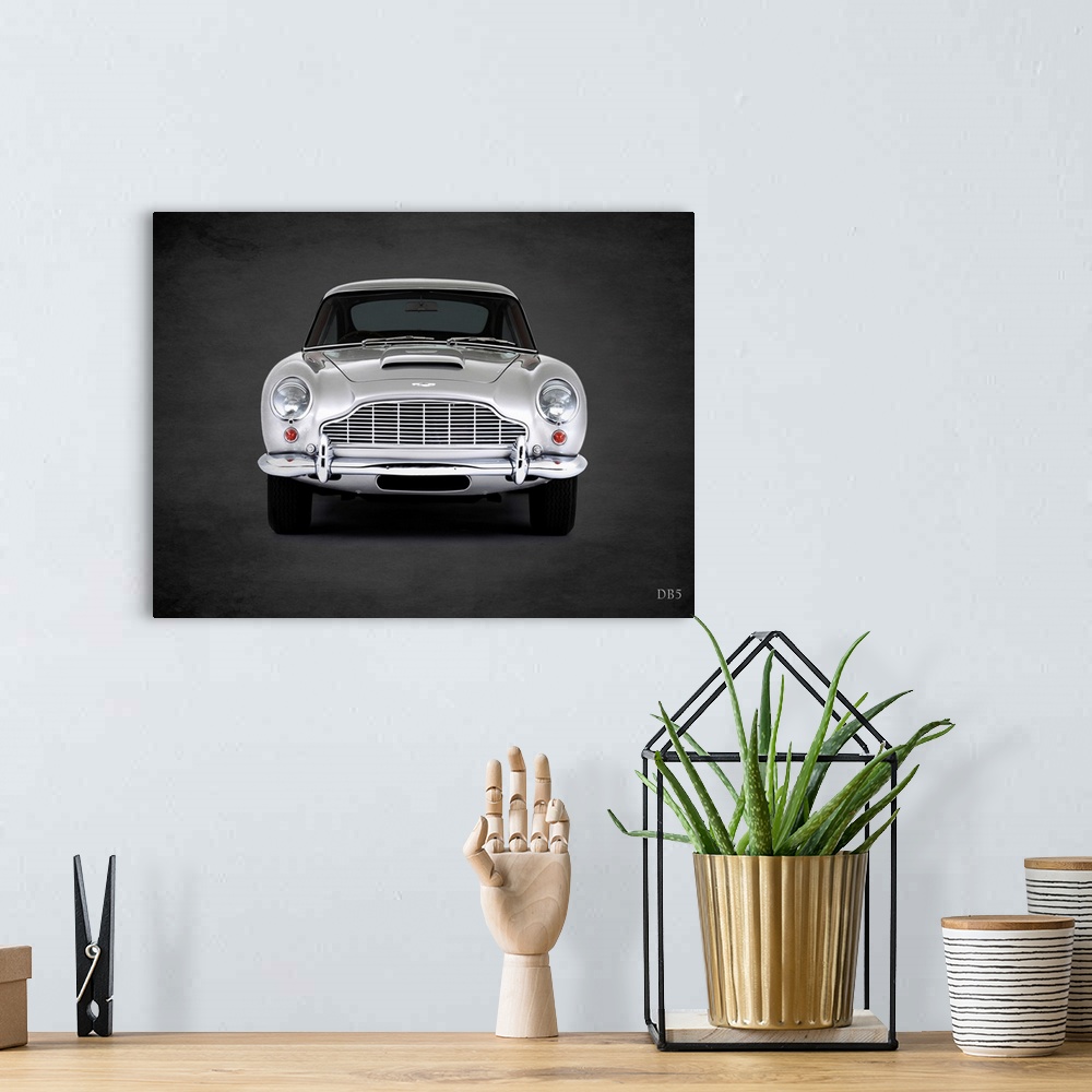 A bohemian room featuring Photograph of a silver 1965 Aston Martin DB5 printed on a black background with a dark vignette.