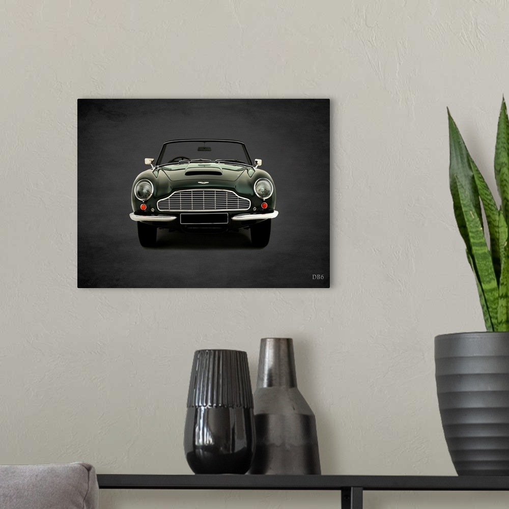 A modern room featuring Photograph of a dark green 1965 Aston Martin DB6 printed on a black background with a dark vignette.