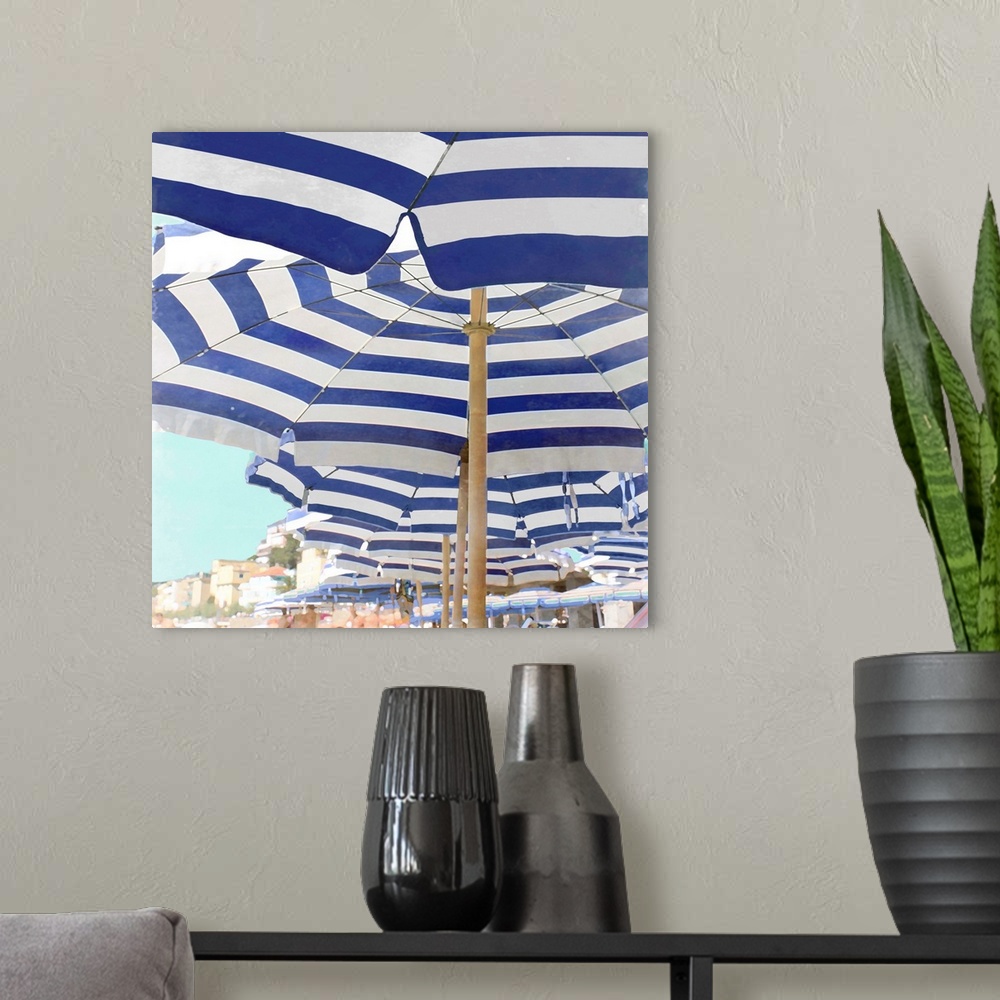 A modern room featuring Square decor with blue and white striped beach umbrellas lined up on the beach.