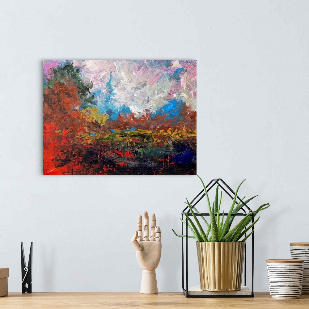 A bohemian room featuring Abstract painting of a colorful landscape with bright red and burnt orange hues.