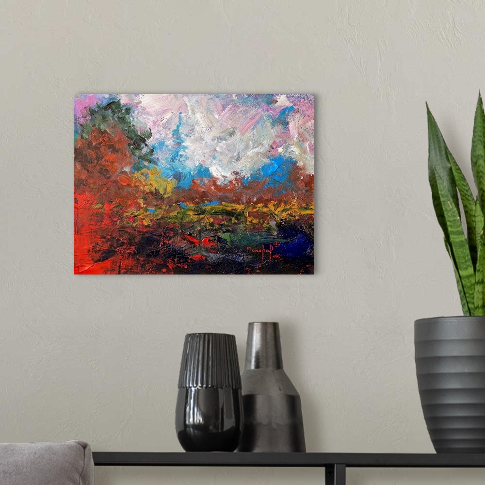 A modern room featuring Abstract painting of a colorful landscape with bright red and burnt orange hues.