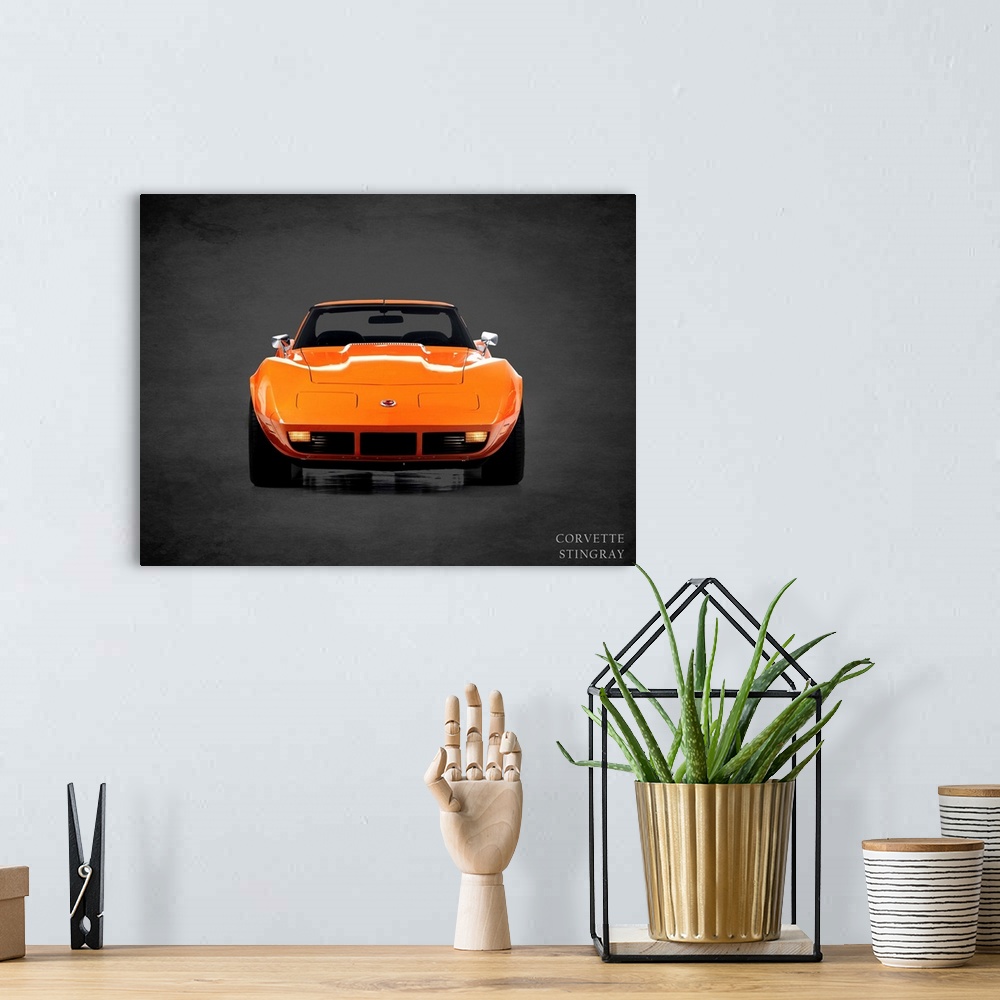 A bohemian room featuring Photograph of an orange 1974 Chevrolet Corvette Stingray printed on a black background with a dar...