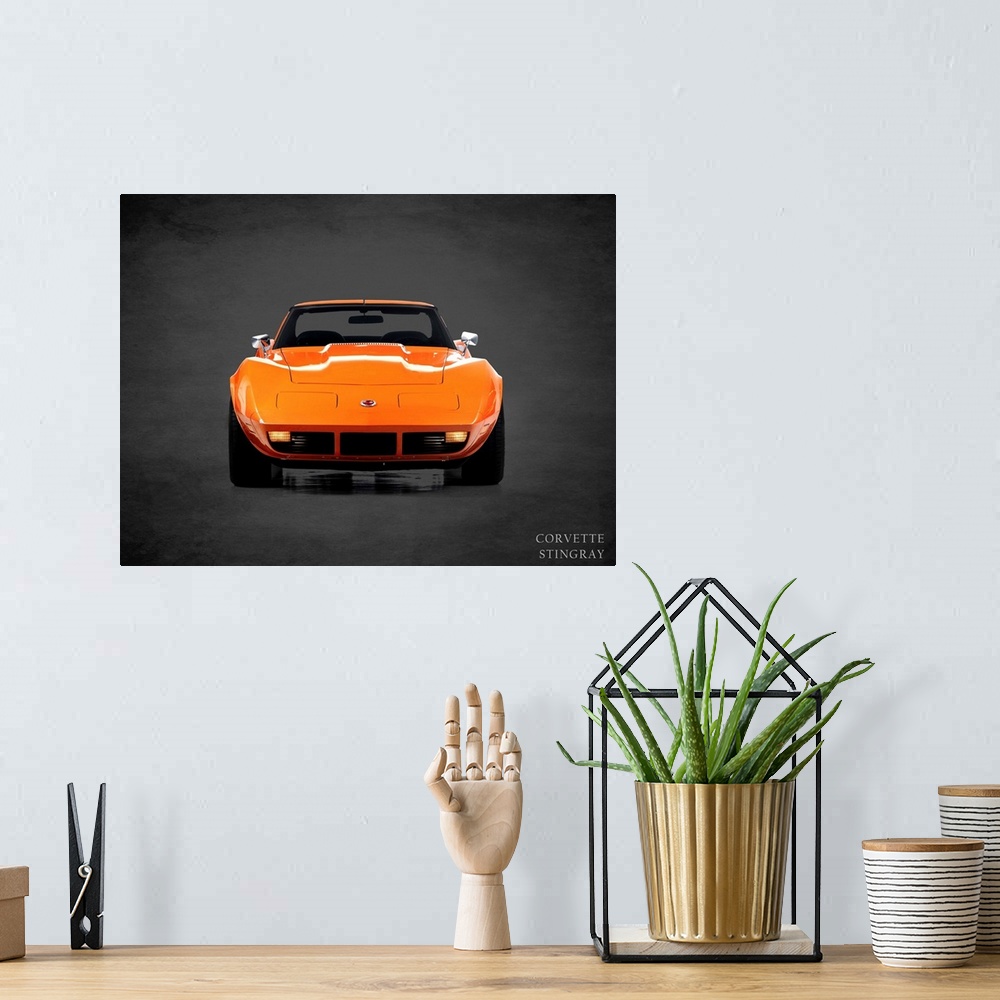A bohemian room featuring Photograph of an orange 1974 Chevrolet Corvette Stingray printed on a black background with a dar...