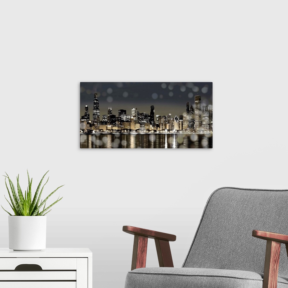 A modern room featuring The Chicago skyline lit up at night with from across the water with bokeh lights in the foreground.