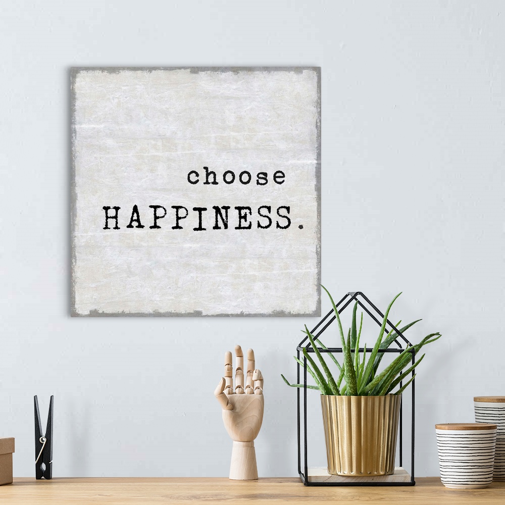 A bohemian room featuring "Choose Happiness" on a square background in shades of gray.