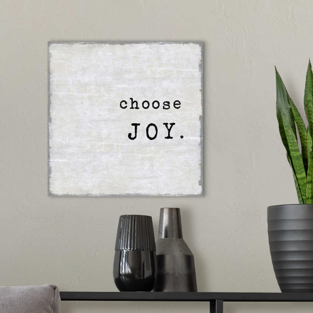 A modern room featuring "Choose Joy" on a square background in shades of gray.