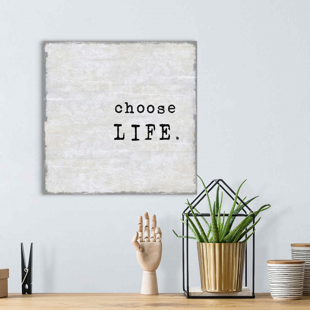 A bohemian room featuring "Choose Life" on a square background in shades of gray.