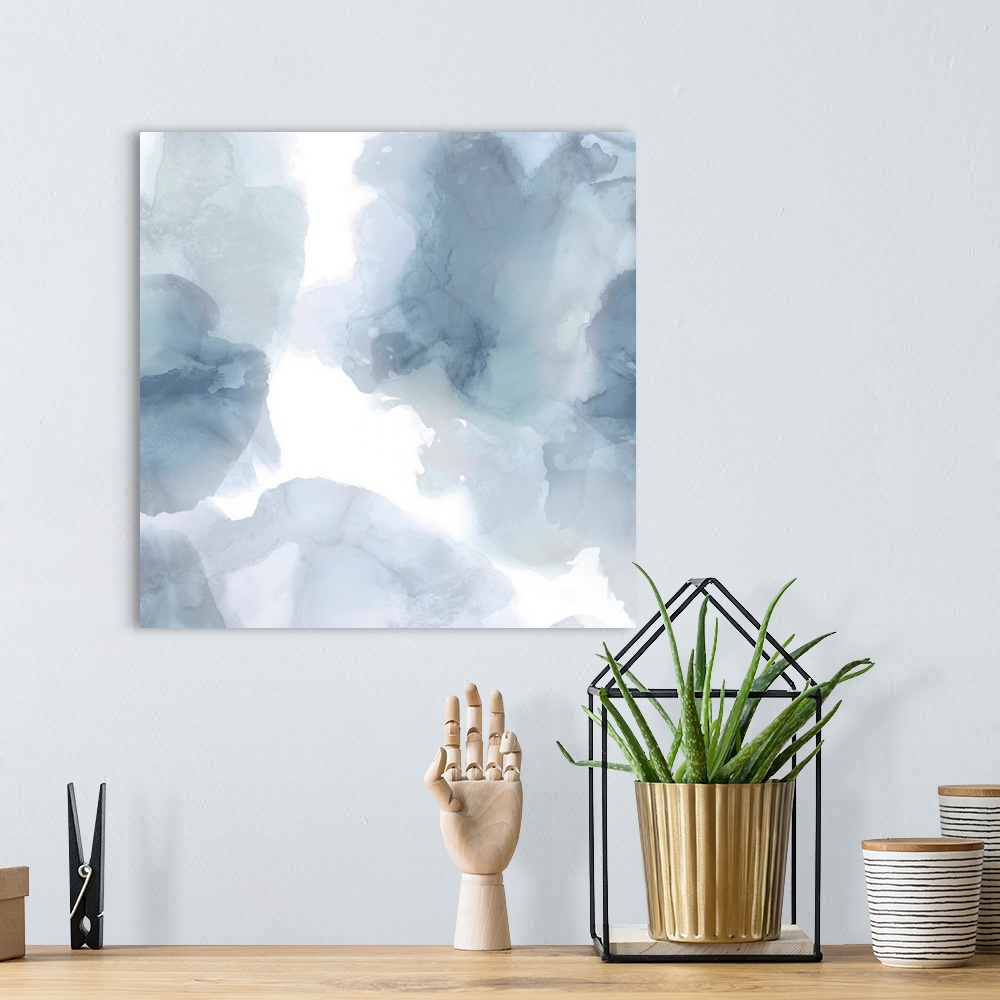 A bohemian room featuring Abstract painting with translucent blue and gray hues splattered together on a white background.