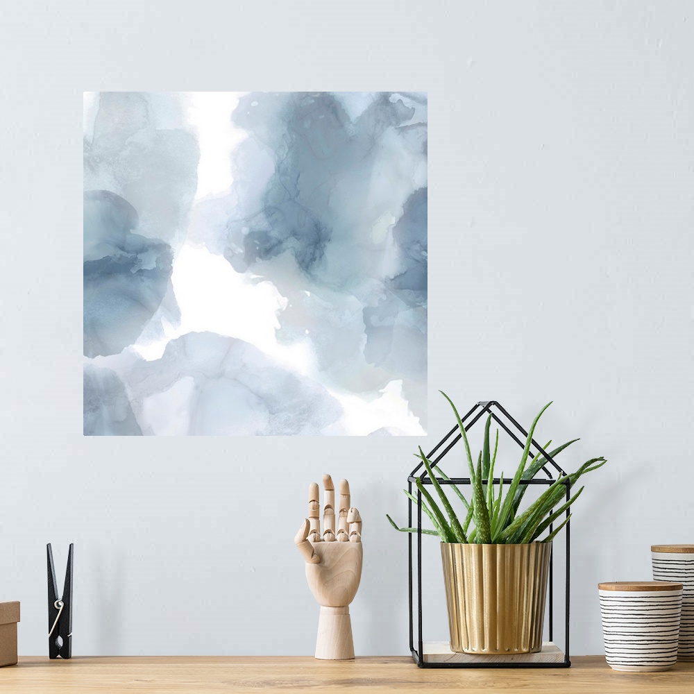 A bohemian room featuring Abstract painting with translucent blue and gray hues splattered together on a white background.
