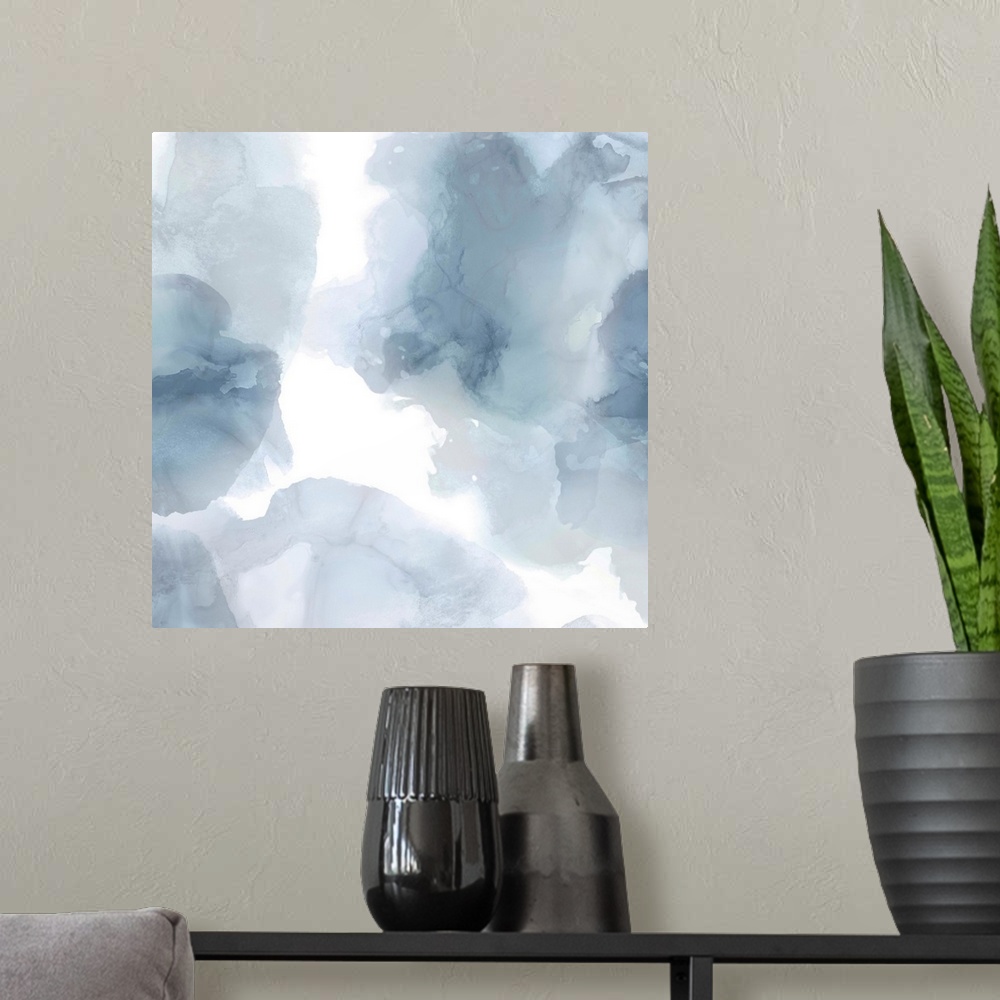 A modern room featuring Abstract painting with translucent blue and gray hues splattered together on a white background.