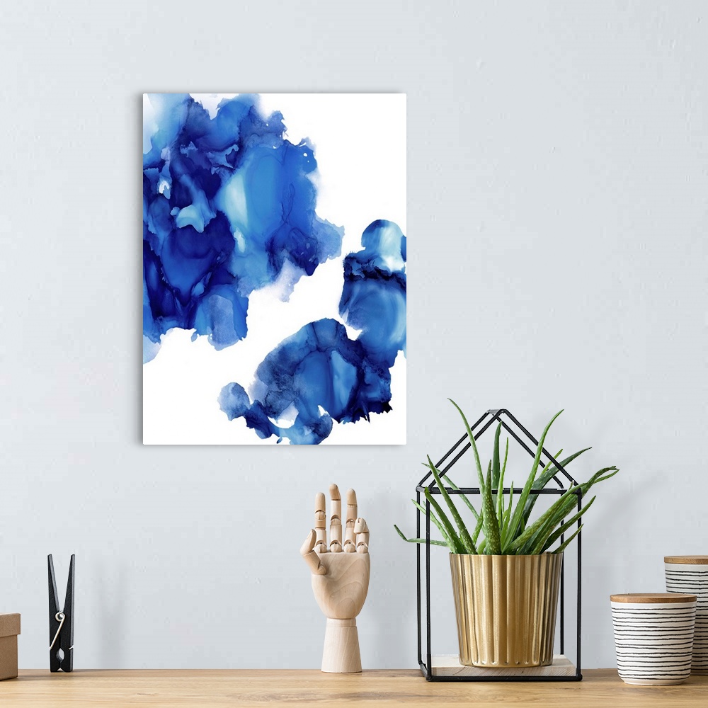 A bohemian room featuring Abstract painting with indigo hues splattered together on a white background.