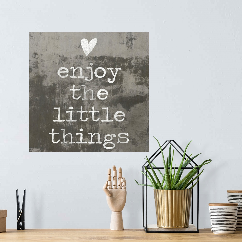A bohemian room featuring "enjoy the little things" written in white with a heart above, on a background made with dark and...