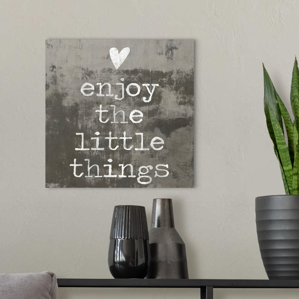 A modern room featuring "enjoy the little things" written in white with a heart above, on a background made with dark and...