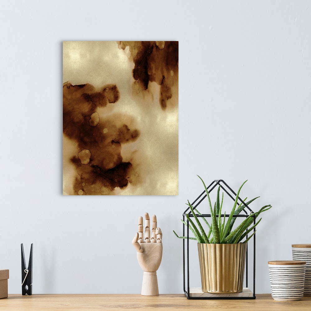 A bohemian room featuring Abstract painting with bronze hues splattered together on a gold background.