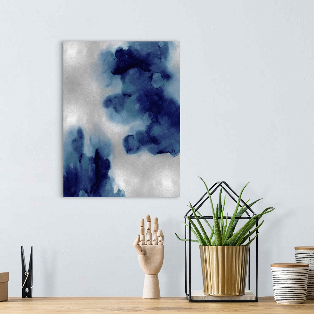 A bohemian room featuring Abstract painting with indigo hues splattered together on a silver background.