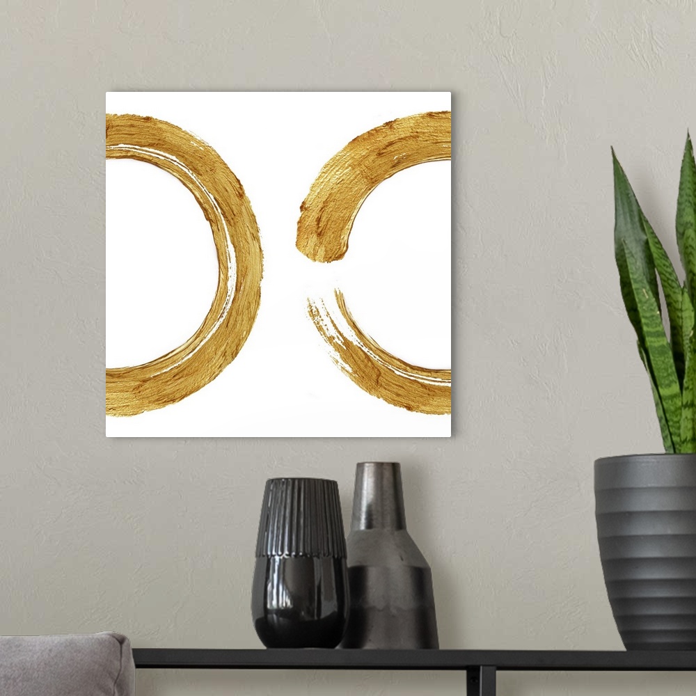A modern room featuring This Zen artwork features two sweeping circular brush strokes in gold over a white background.