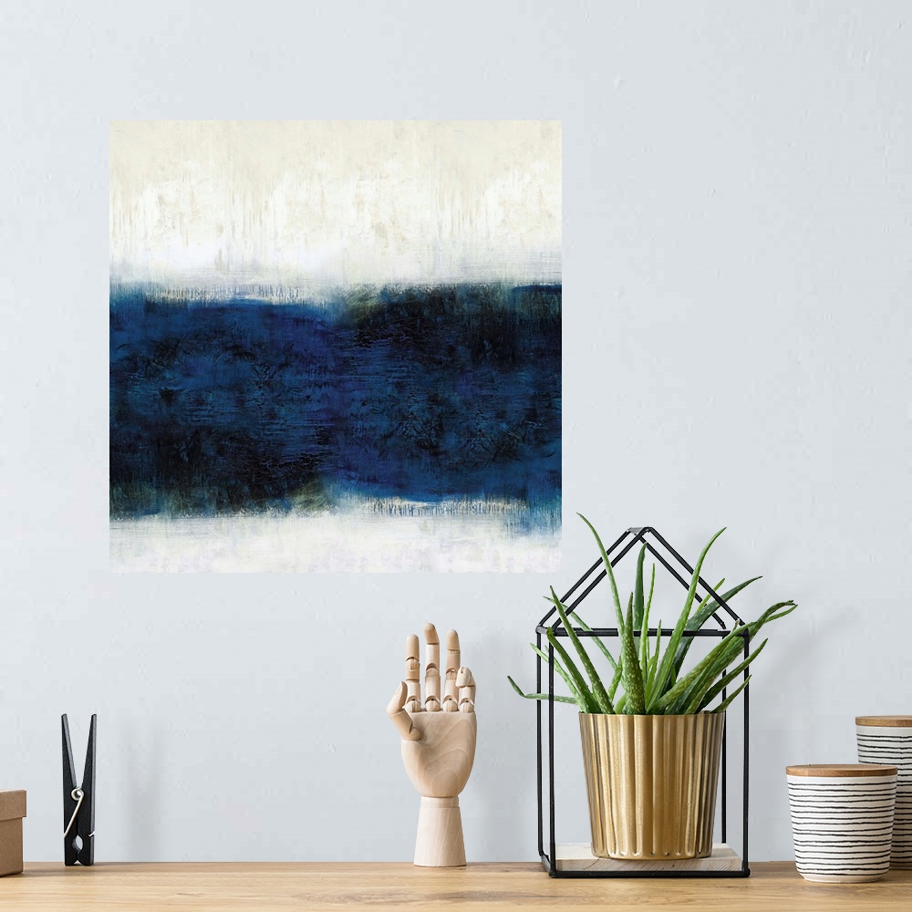 A bohemian room featuring Square abstract painting with a band of deep blue hues in the middle and off-white with tan above...