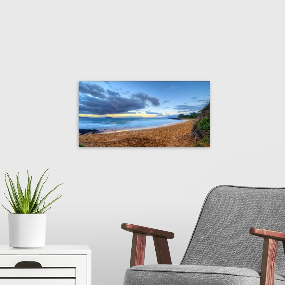 A modern room featuring Landscape photograph of an empty beach in Maui.