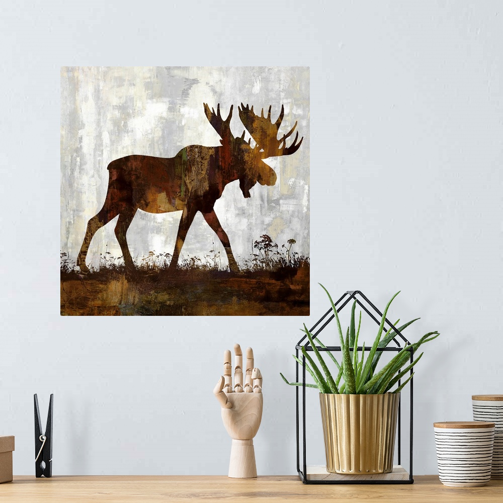 A bohemian room featuring Square decor with a brown and gold silhouette of a moose on a gray, tan, and white background.