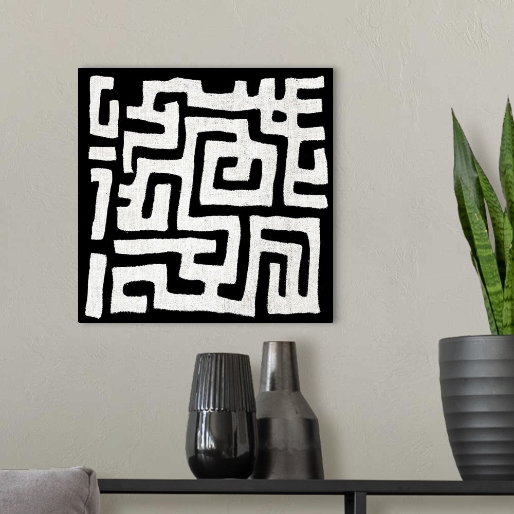 A modern room featuring Square abstract black and white patterned art.